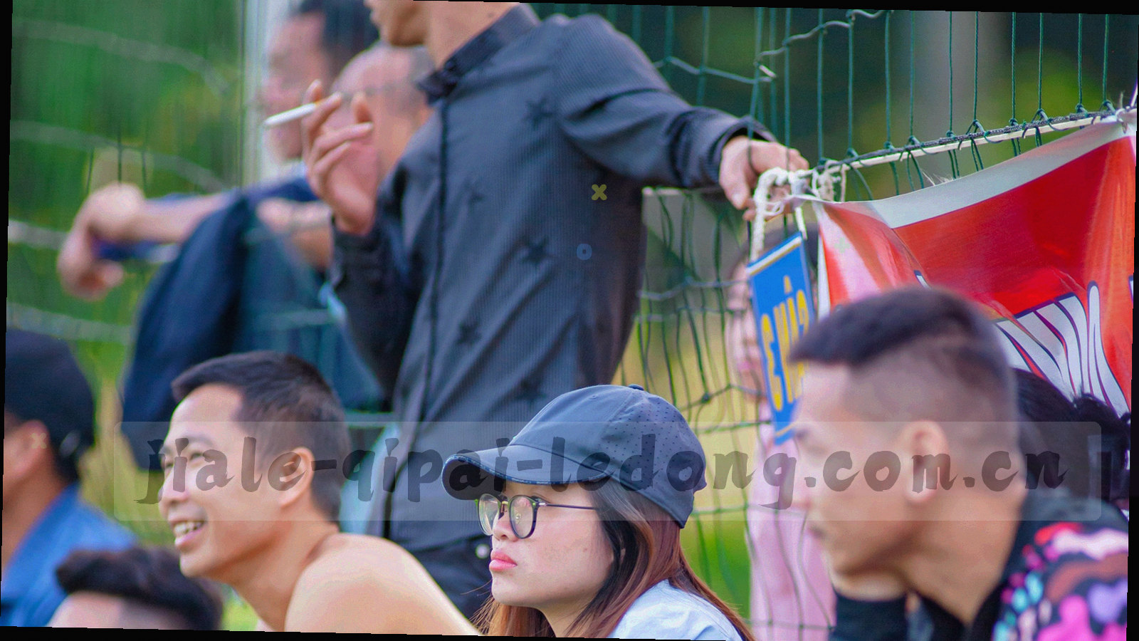 从高处俯视的体育场看台与场地分区线，画面冷调偏蓝